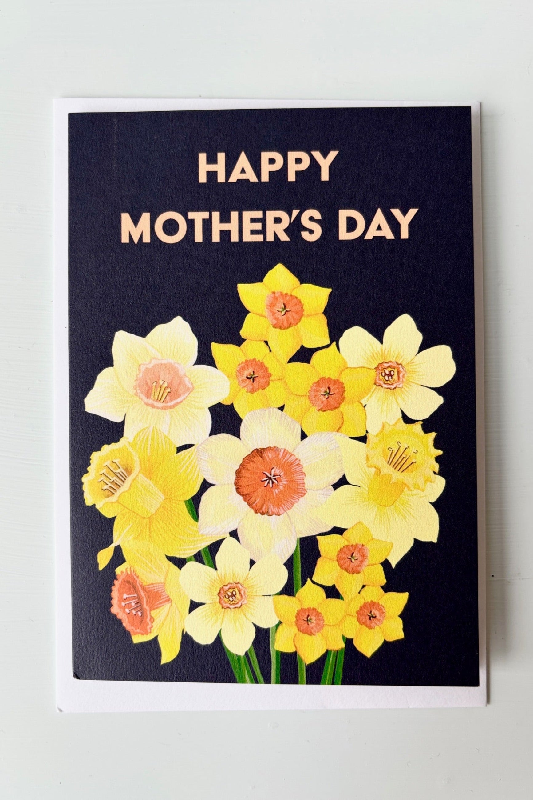 Greeting card with yellow daffodils on a black background with the words Happy Mother's Day on the front. ©Sprout Home
