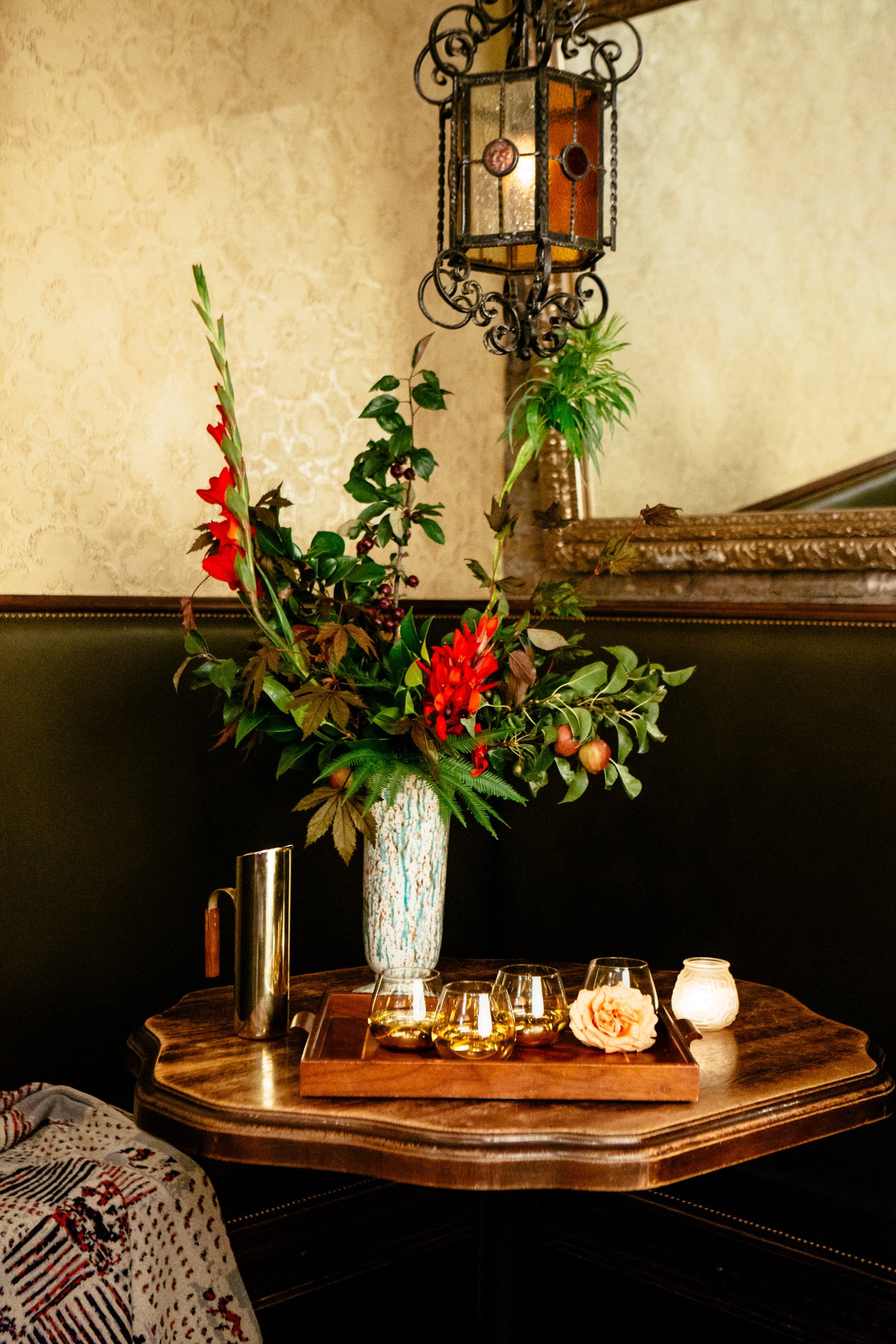 Floral arrangement at Bar Deville featuring red and green. Floral by SPROUT HOME. Photo by Heather Talbert