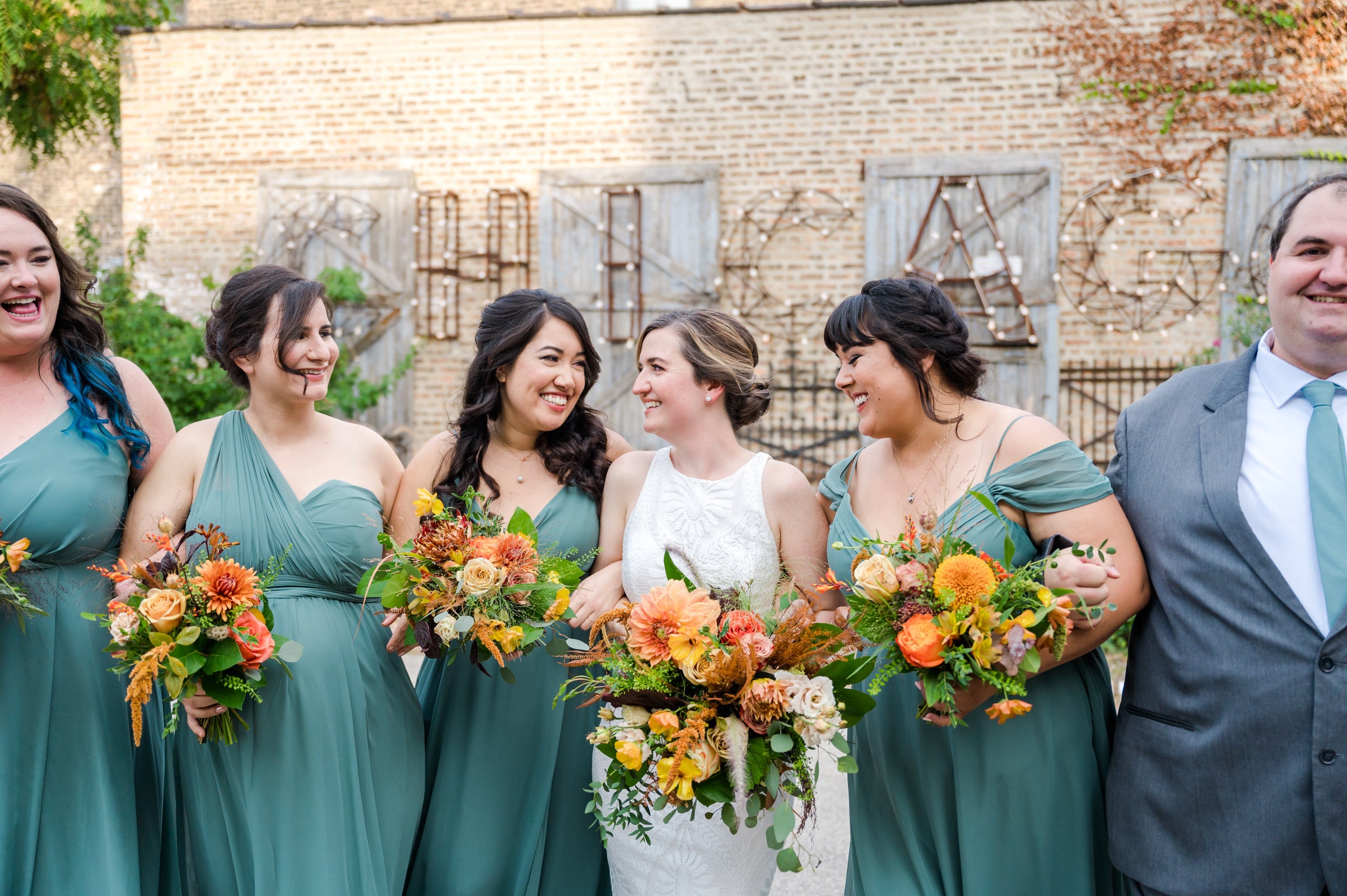 Wedding at Salvage One in Chicago, sage colored dresses for bridesmaids, with bride and all holding floral bouquets by Sprout Home. Photograph by Winterlyn Photography.