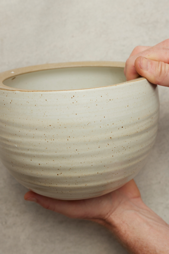 Spherical Hanging Planter
Creamy White Speckle
by Angus & Celeste being held in hand showing the finish.
