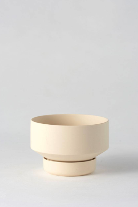 Clay colored Collector's Gro Pot from Angus & Celeste being shown empty and against a white wall.