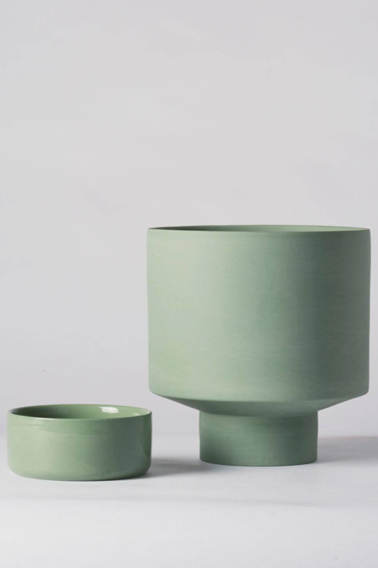 An olive green Collector's Gro Pot from Angus & Celeste being shown with its drain tray separated and to the side.