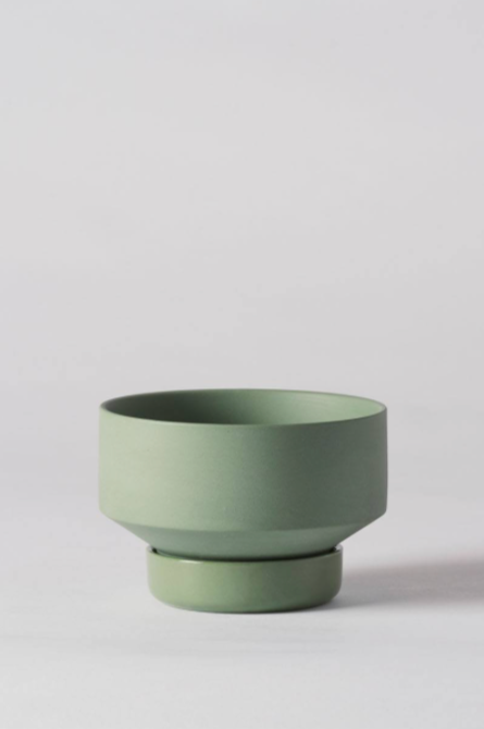 A small Olive Green Collector's Gro pot by Angus & Celeste empty and against a white wall.