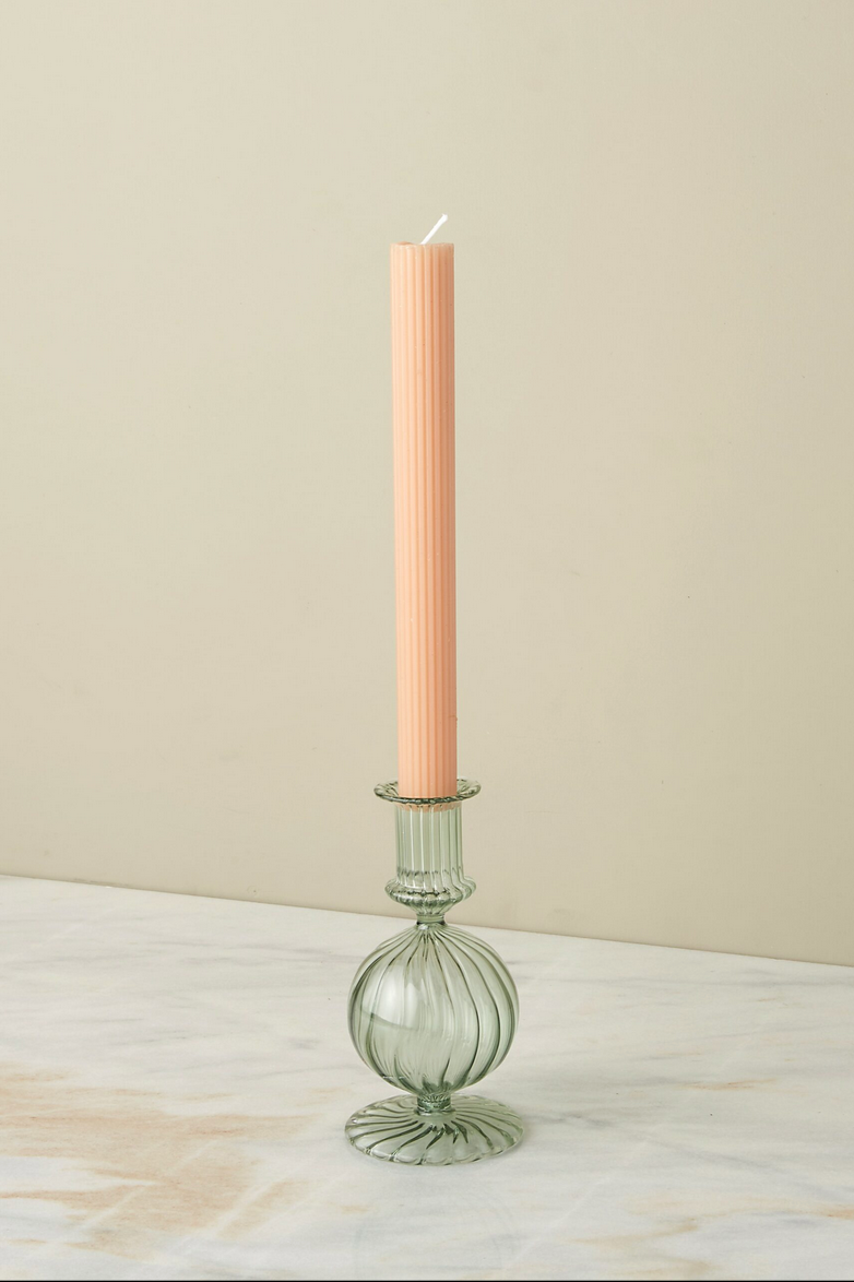 Glass Nahlia candlestick holder in Parakeet color with a peach colored taper candle.
