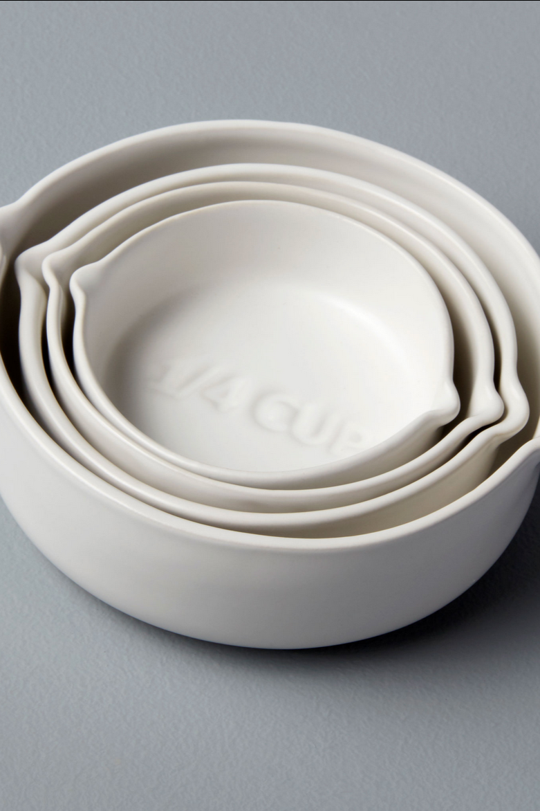 Set of white measuring cups stacked inside each other.