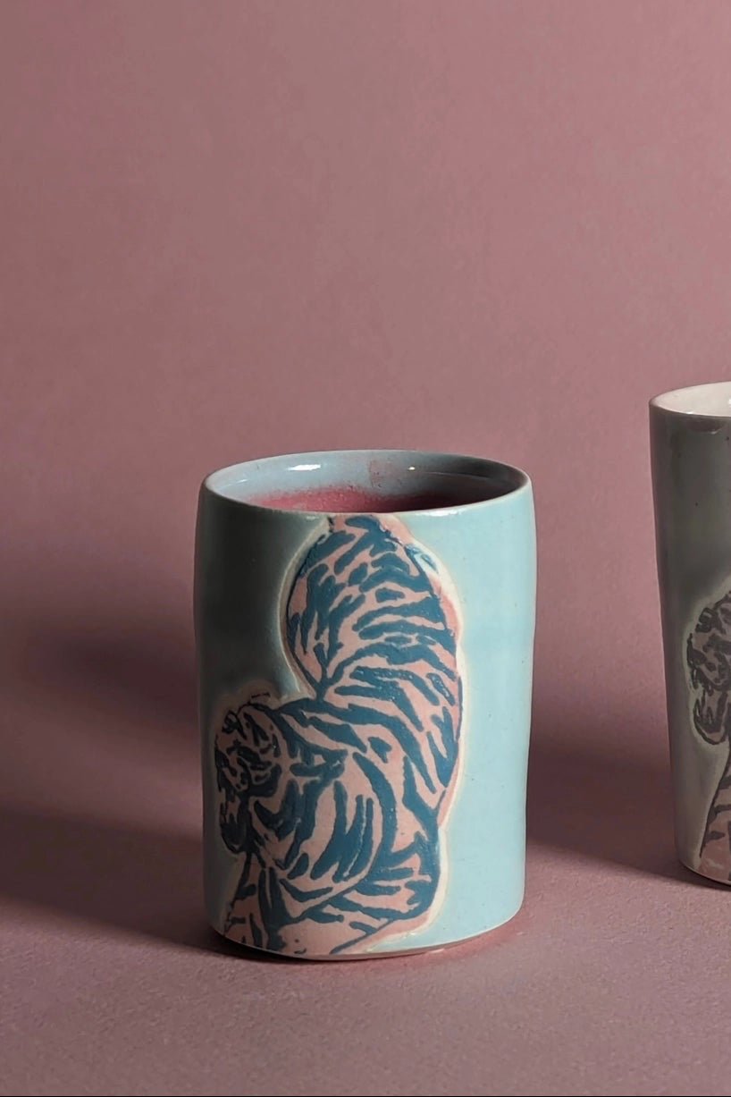 Ceramic cup with animal pattern on a pink background focusing on the Blue Pink shot glass in particular ©City in Bloom Ceramics