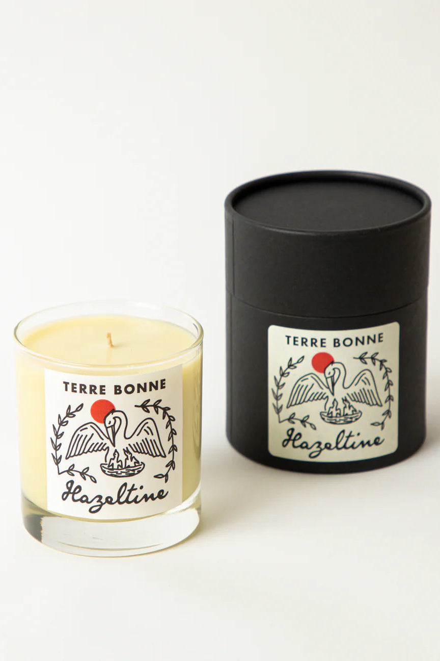 Candle and black cylindrical container with 'Terre Bonne' branding on a white background ©Hazeltine