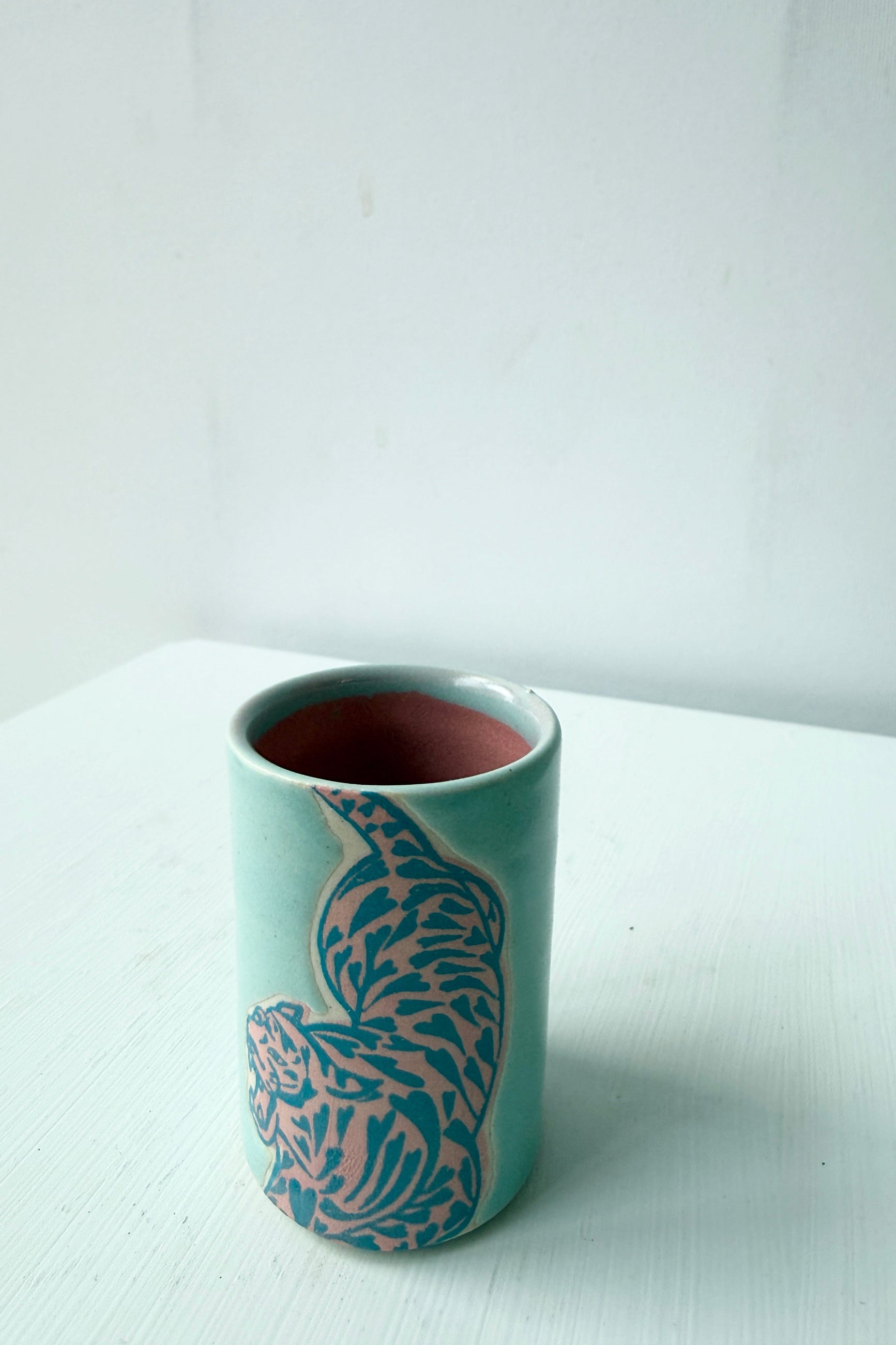 Teal with pink tiger design shot glass by city in Bloom ceramics on a white surface ©Sprout Home