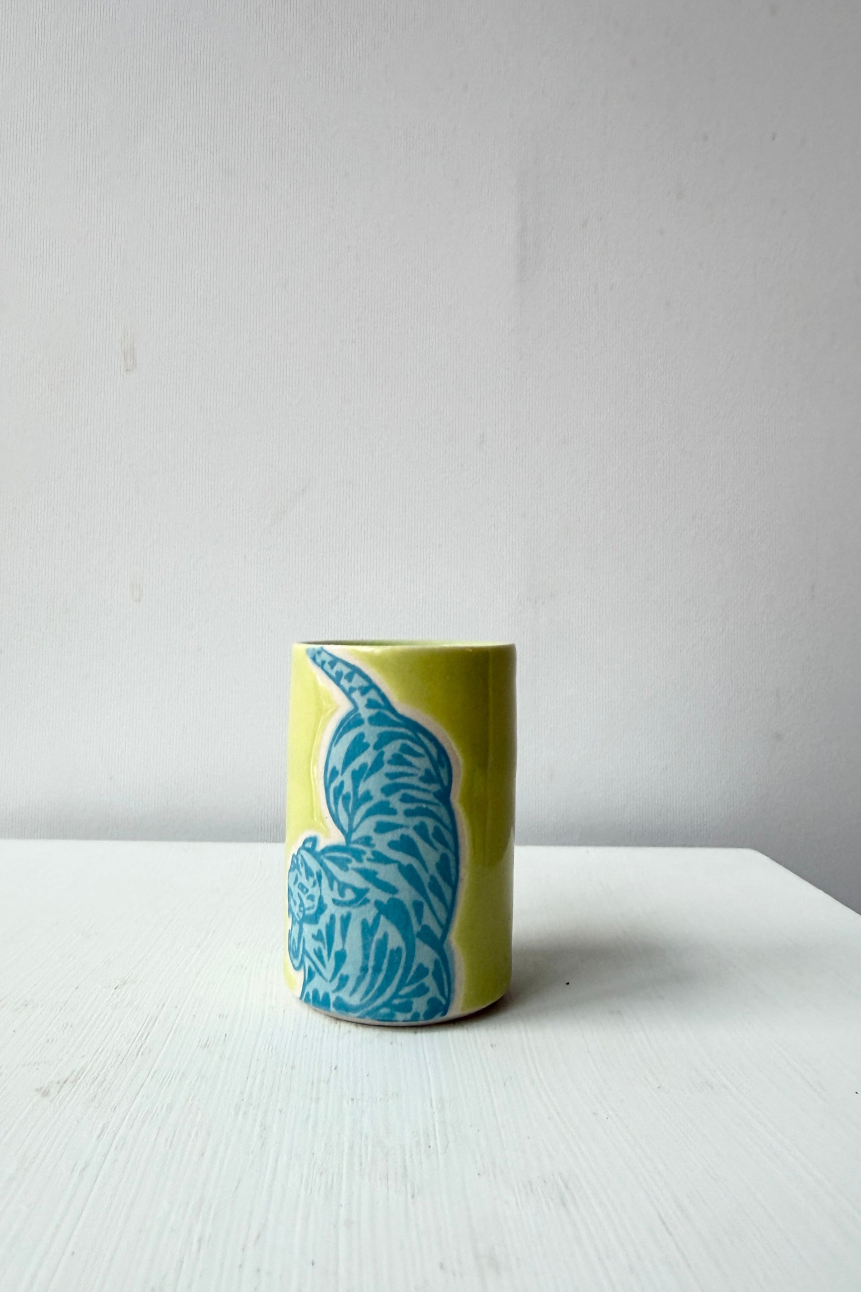 hand made by City in Bloom Ceramics Ceramic cup with blue tiger on a white surface and light gray background ©Sprout Home