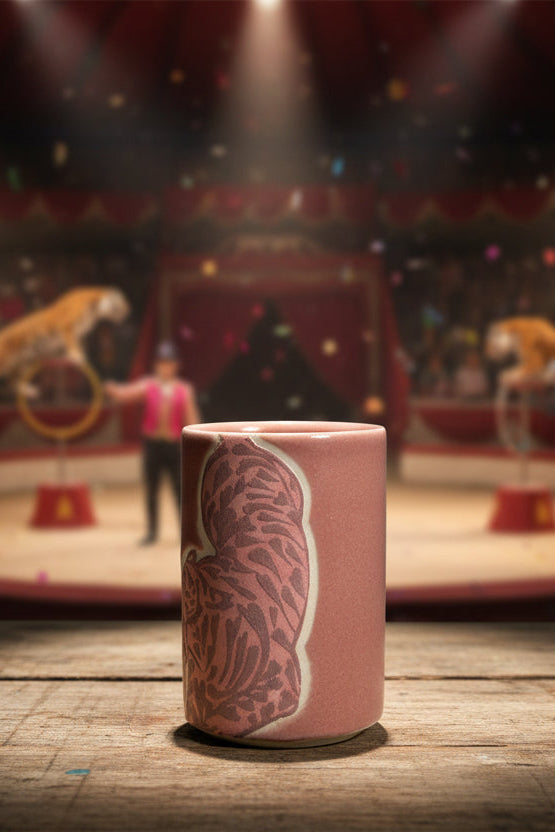 Ceramic tumbler with pink tiger pattern by City in Bloom ceramics in front of a circus show in spotlight ©Sprout Home