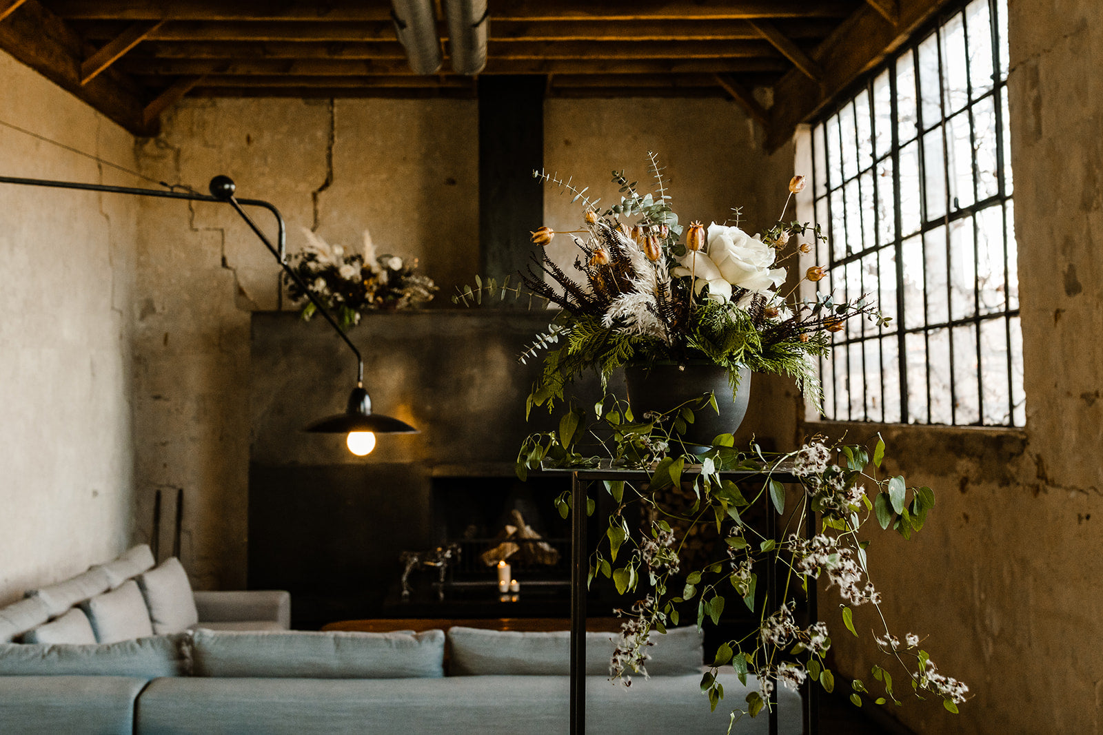Todd & Michael elopement floral by SPROUT HOME. White and winter floral and greenery on a pedestal and fireplace mantel. Photo by TM Inspired Photography