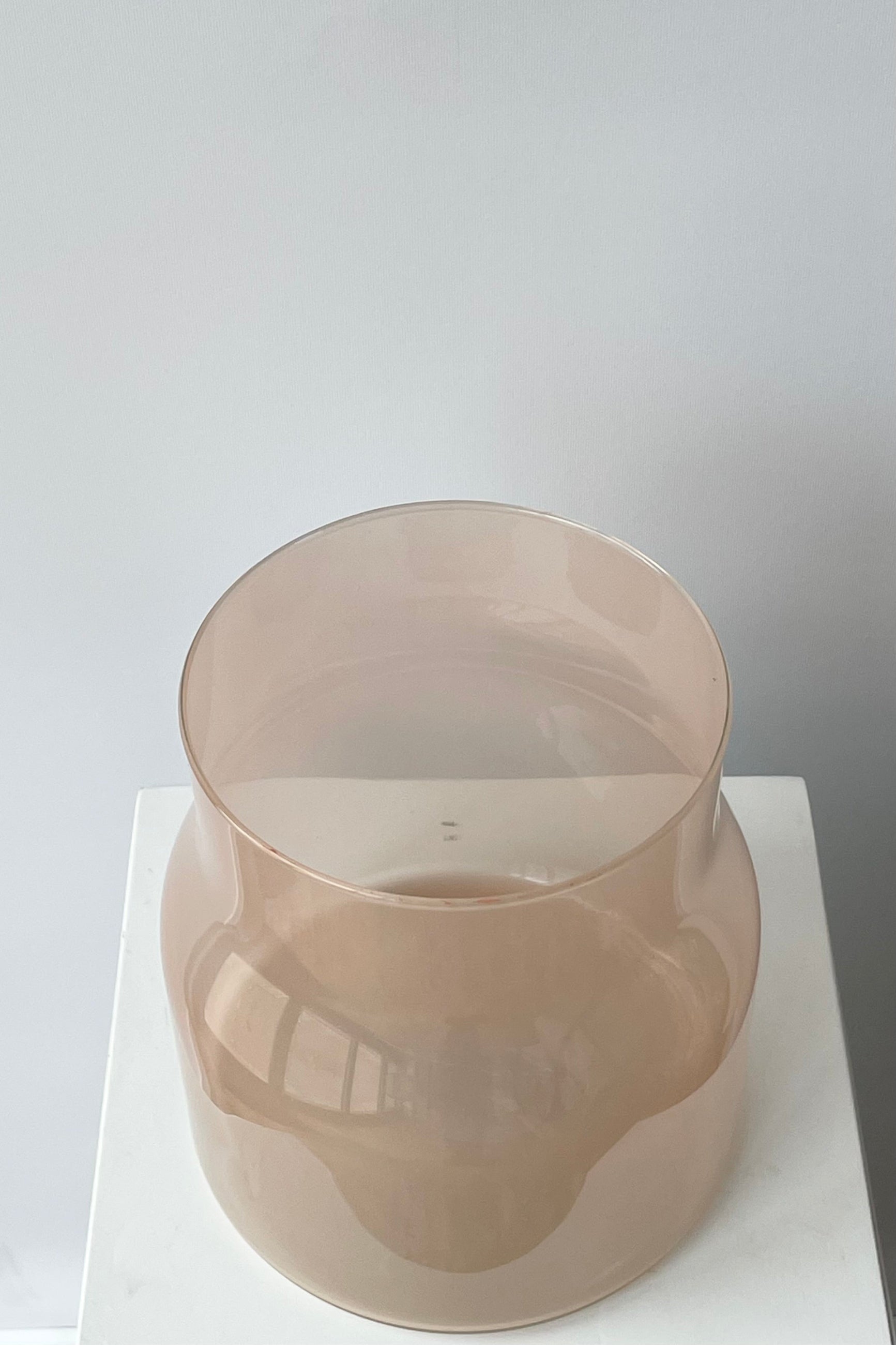 Photo looking down on a semi-opaque Bodii glass vase on a white shelf against a white wall. ©Sprout Home