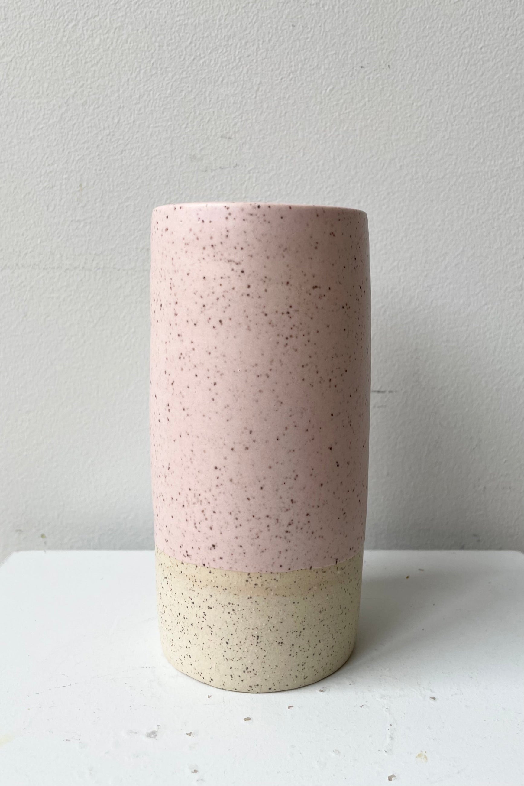 Small Jacqueline vase in Pink Speckle against a white wall. ©Sprout Home
