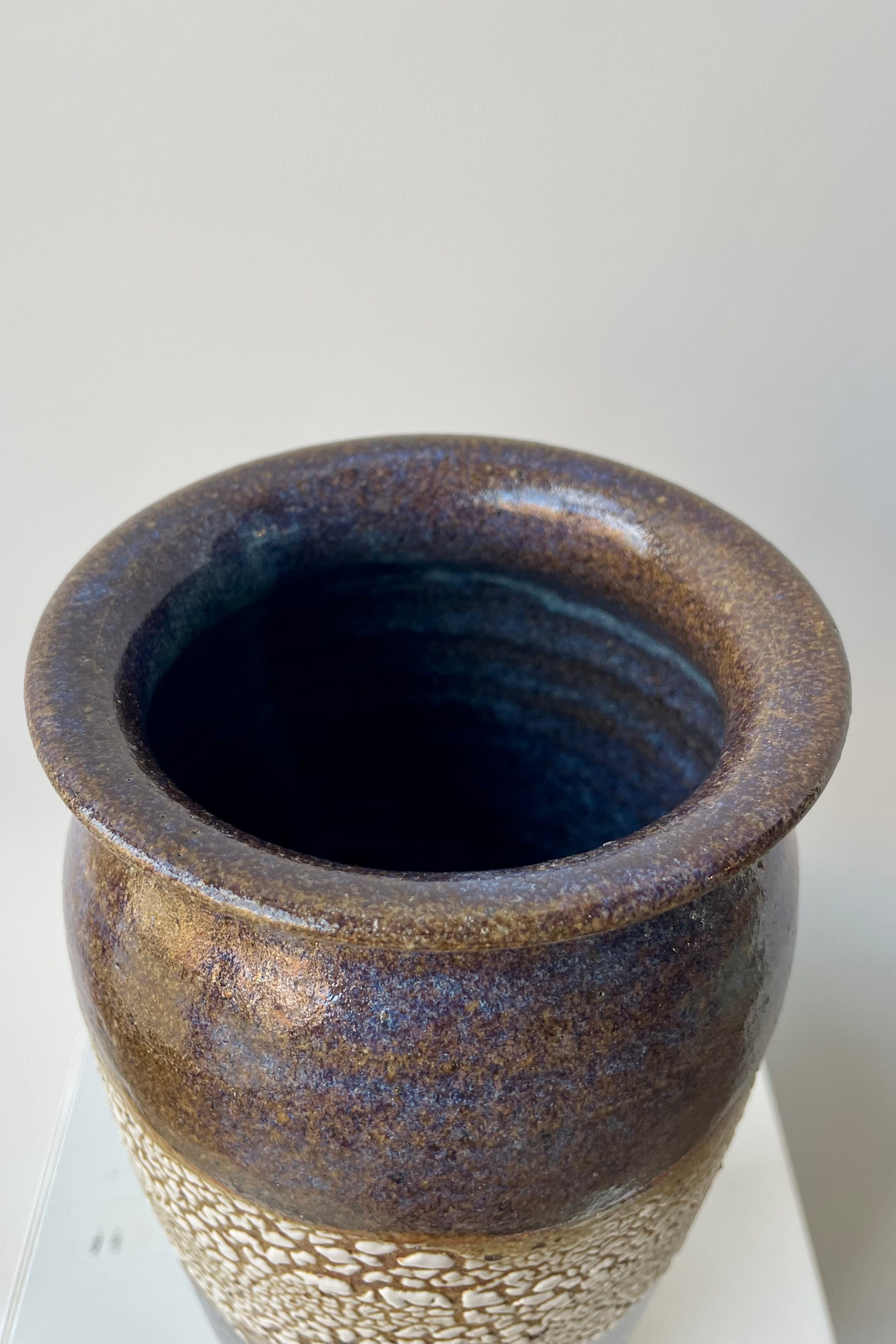 Bruning Pottery "super crackle" glazed tall ceramic vase in front of white background looking down