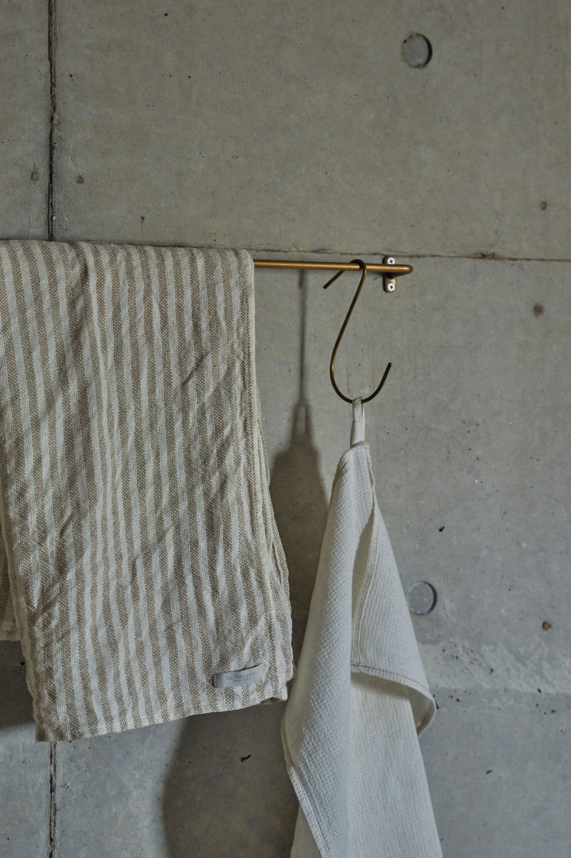 brass hook by Fog Linen Work on a brass towel bar and linens.