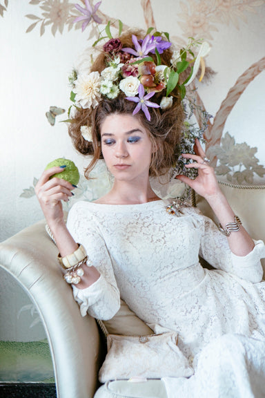 Floral photoshoot by Sprout Home at the Women's Athletic Club of Chicago photographed by Heather Talbert. Floral hair with model lounging on on chaise. Baroque and romantic.