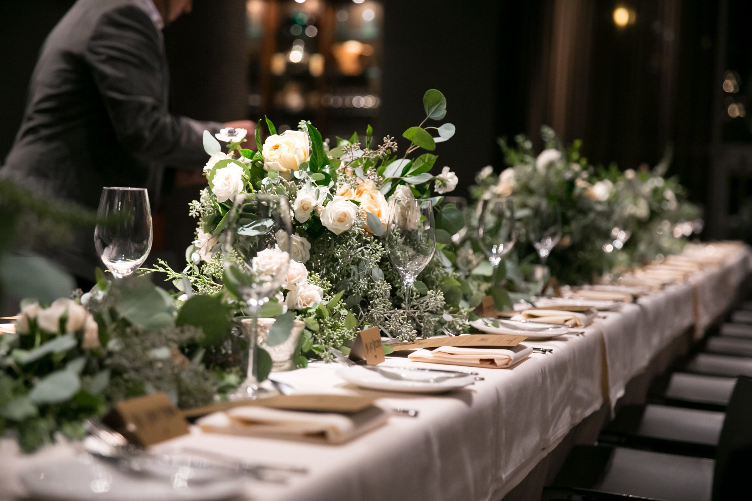 Zachery and Brians wedding with a reception table garland that is thick and lush with greenery and cream garden roses, lush and plush. Floral by Sprout Home. Photograph by Slack Photography LLC