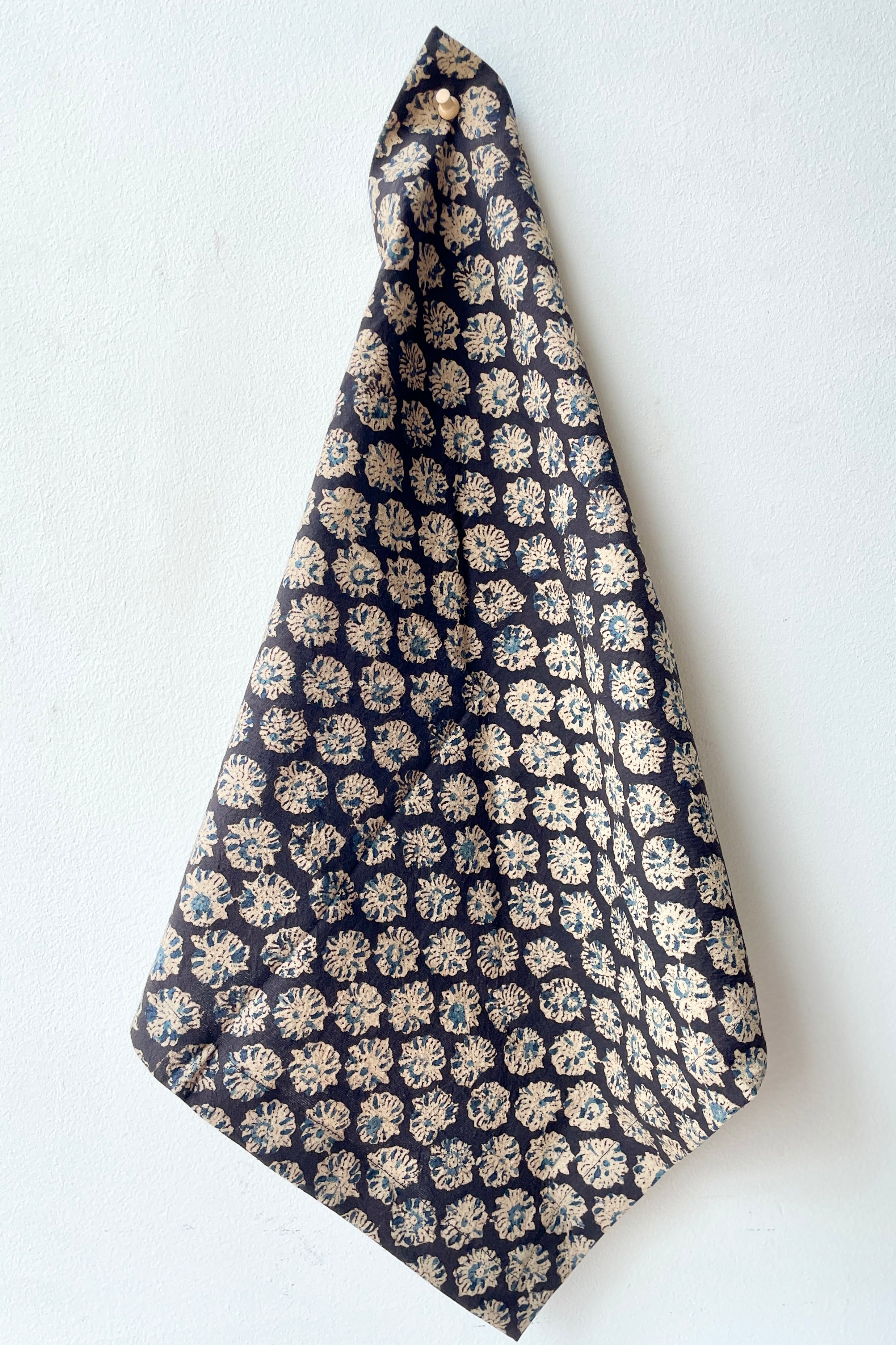 The Capri Anika napkin hanging from a white wall.