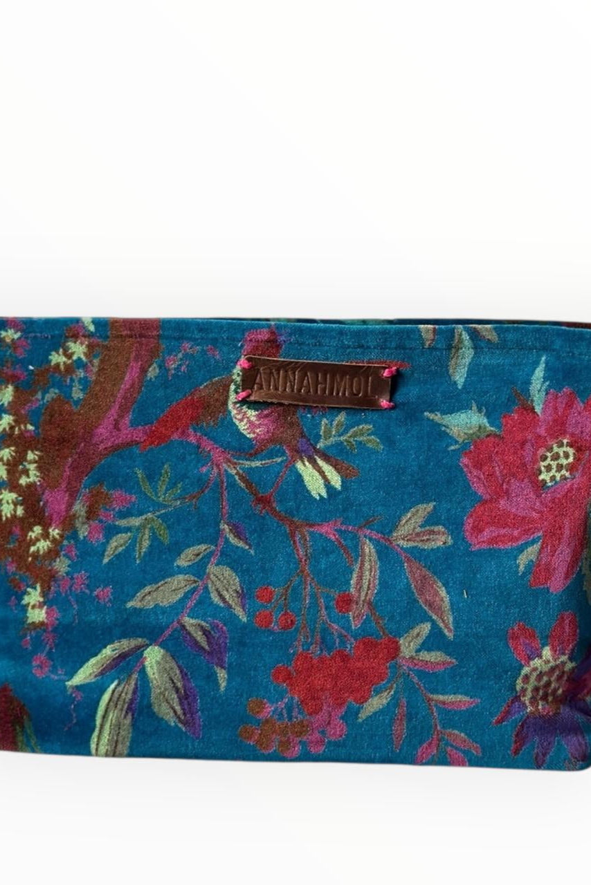 Floral blue and pink patterned pouch with a brand tag on a white background ©Annahmol