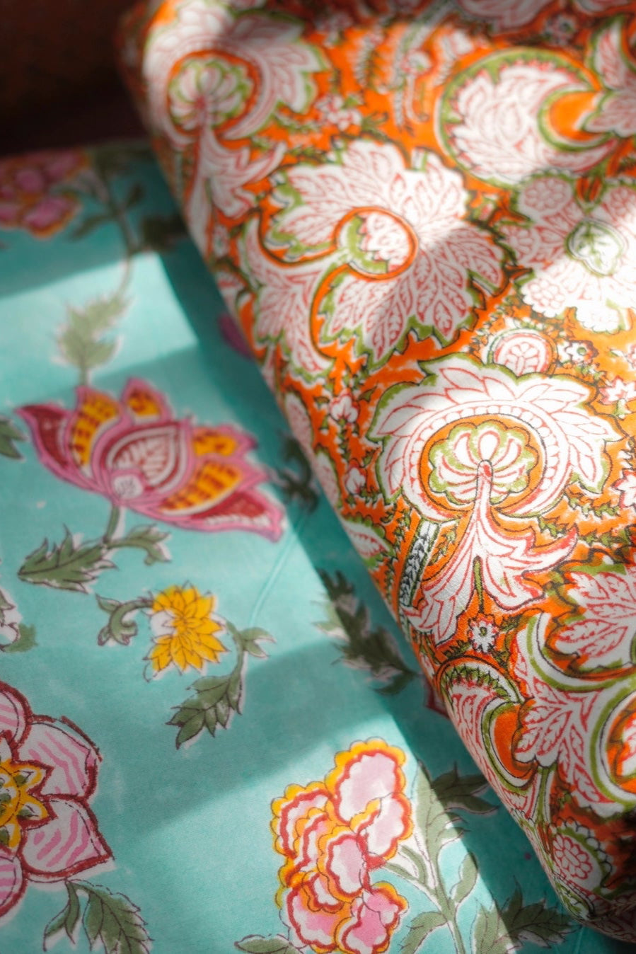 Stack of two Block Print Reversible Summer Cotton Blanket colorful folded fabrics with floral patterns on a light background ©Annahmol