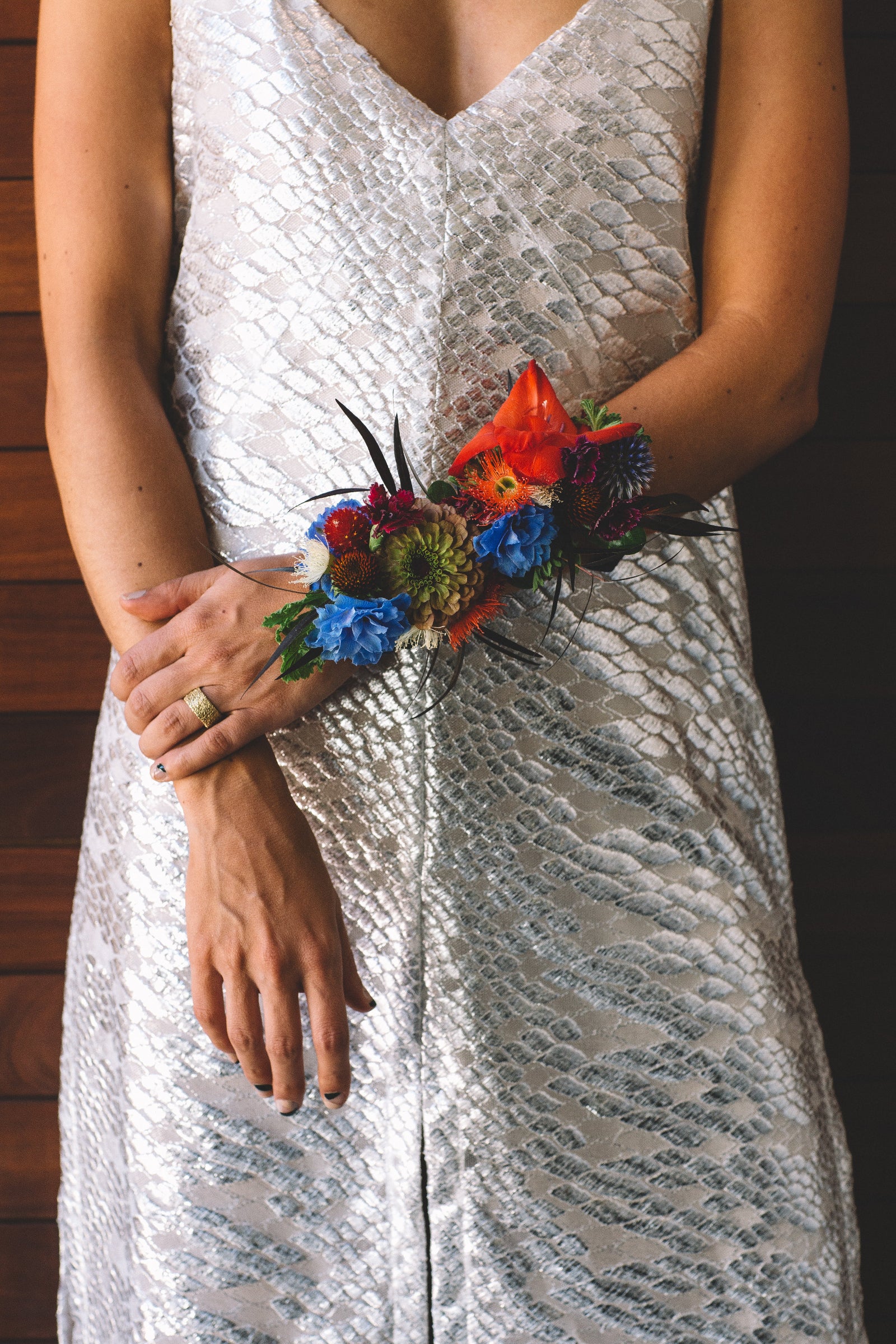 Sprout Home wrist floral arrangement in bright red and blue. Photographed by Stephanie Bassos