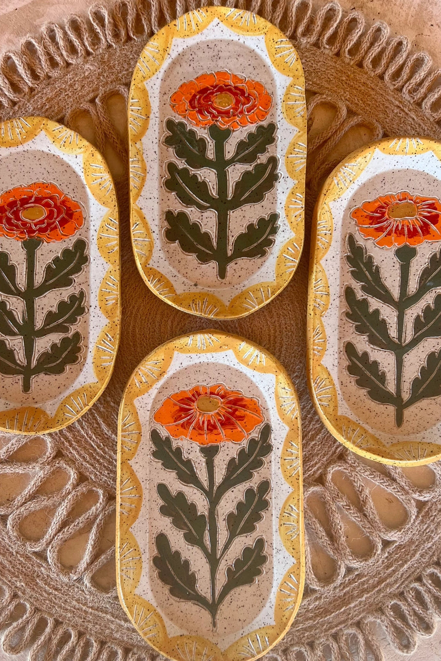 Decorative Goldie marigold dishes with floral patterns on a textured surface ©Tough Kitty Design