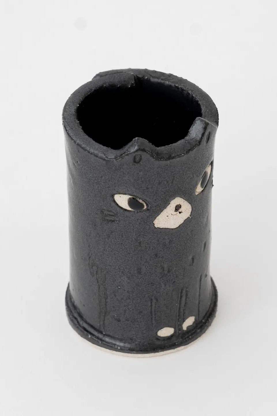 Black cylindrical ceramic vase with cat face design on a white background ©Great Zakka