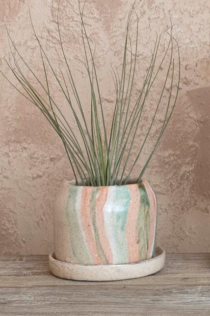 The hand painted terracotta striped planter with an airplane inside