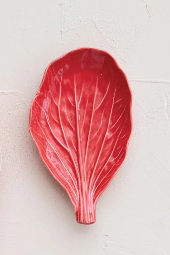 A red leaf-shaped ceramic plate on a white surface ©Creative Co-Op
