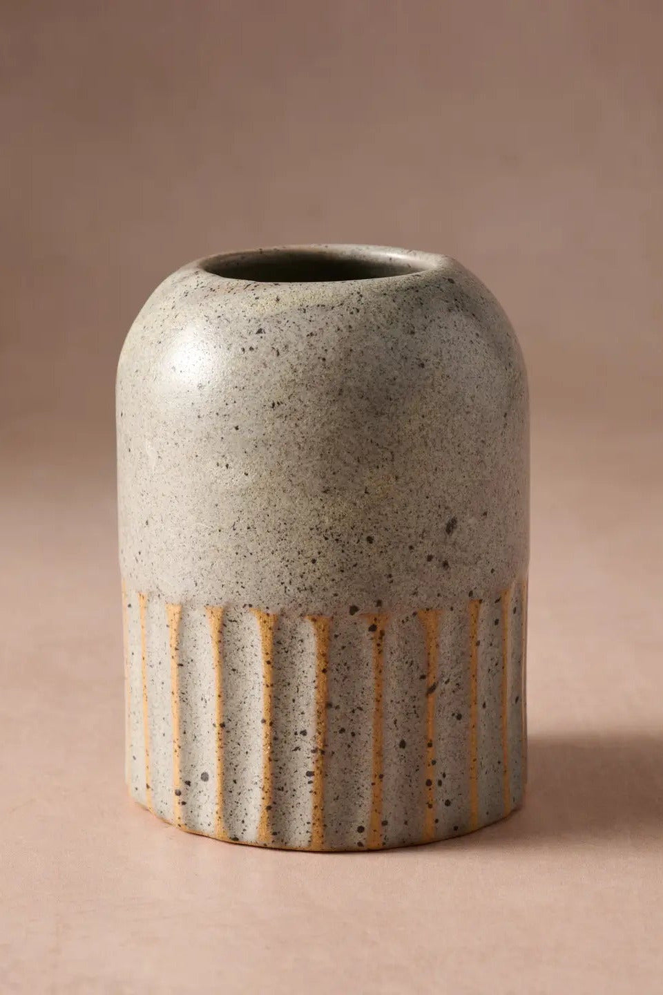 Sundara Fluted Ceramic Vase against a deep rose background ©Ten Thousand Villages