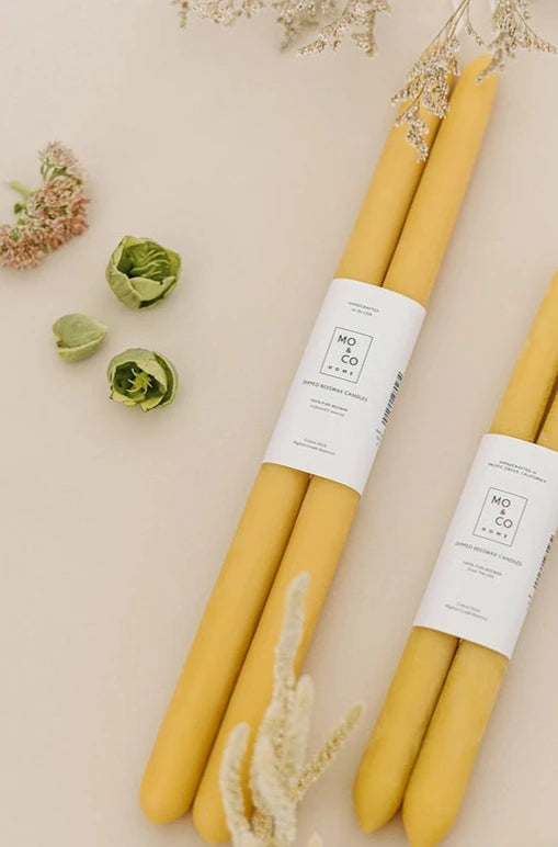 MO & Co beeswax natural gold candles lying down with natural dried floral around them