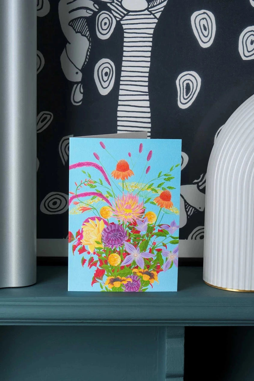 Rebel Rebel card by Stengun Drawing sitting on a ledge in front of graphic white and black wallpaper.