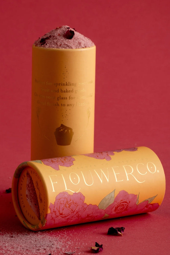 Flowerco rose finishing sugar in a cylindrical packaging on a red background ©Flouwer Co.