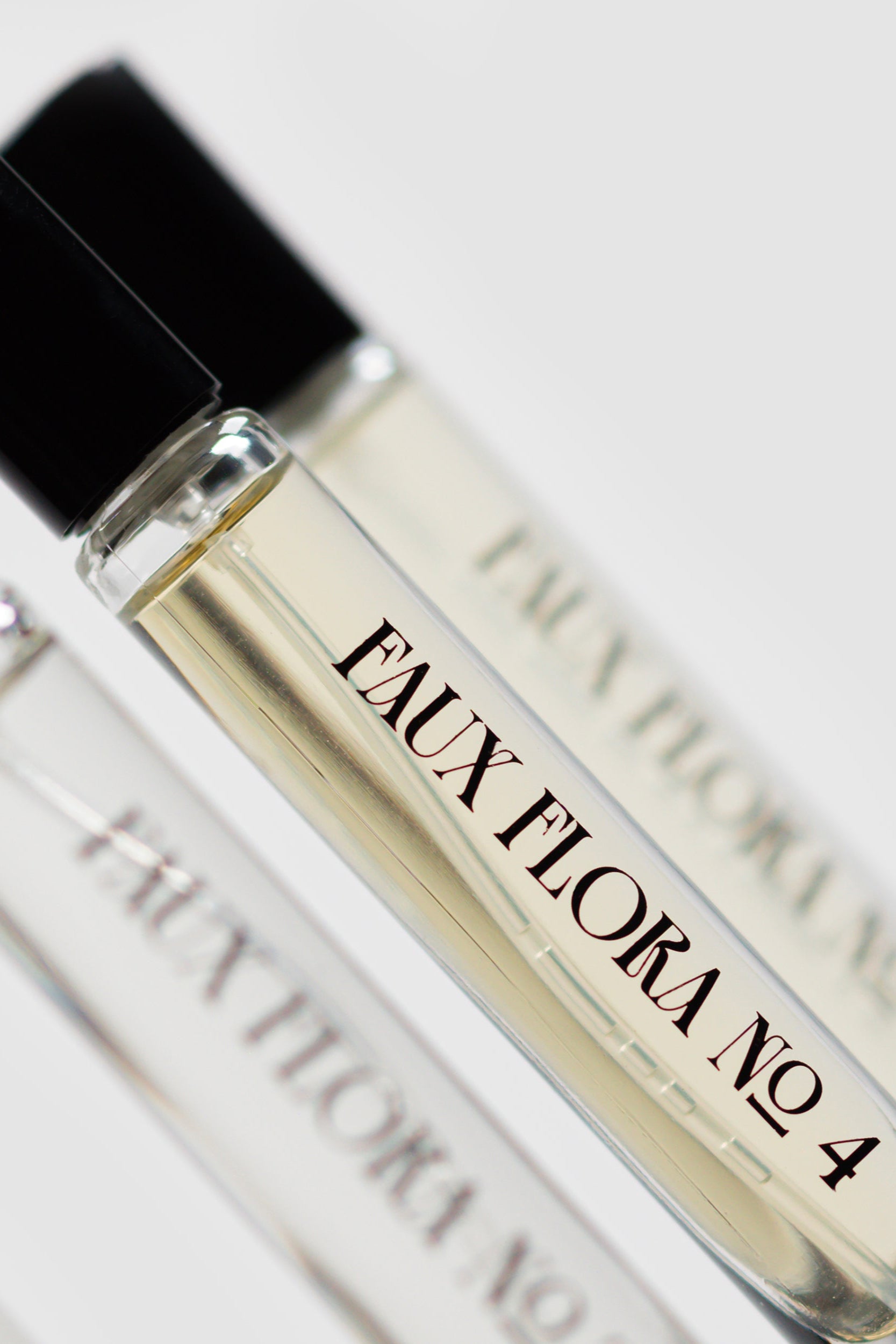 Three small perfume bottles labeled, one being the 'Faux Flora No. 4' of the Faux Floral Discovery Set on a light background. ©Fischersund