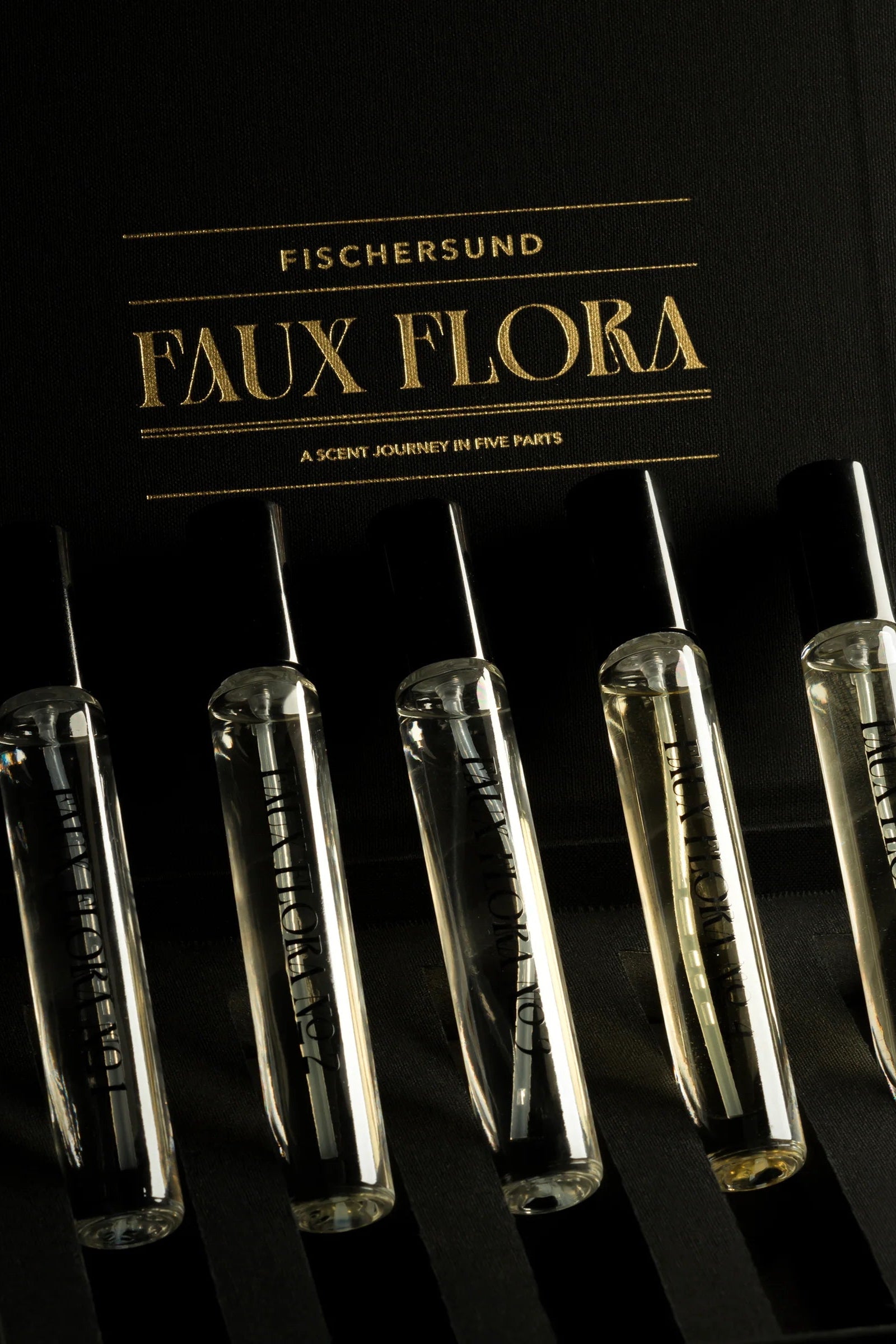 Set of perfume vials with labels on a black background, featuring 'Fischersund Faux Flora' branding. ©Fischersund
