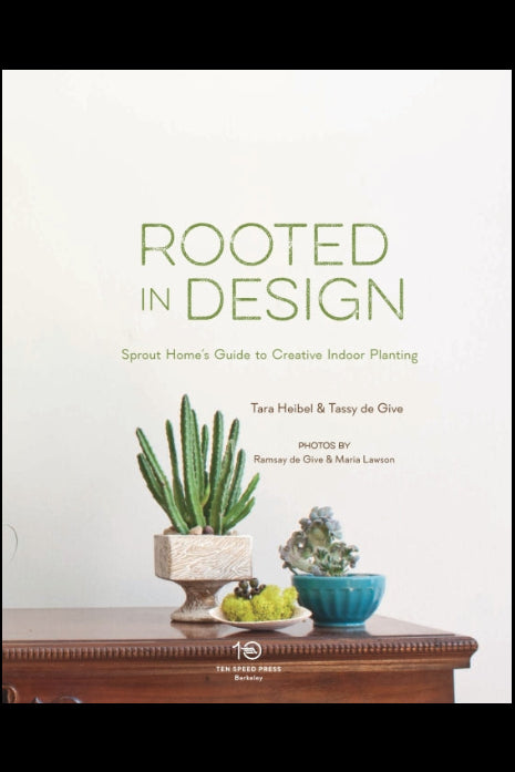 Book inside of 'Rooted in Design' with plants on a wooden surface. ©Penguin Random House