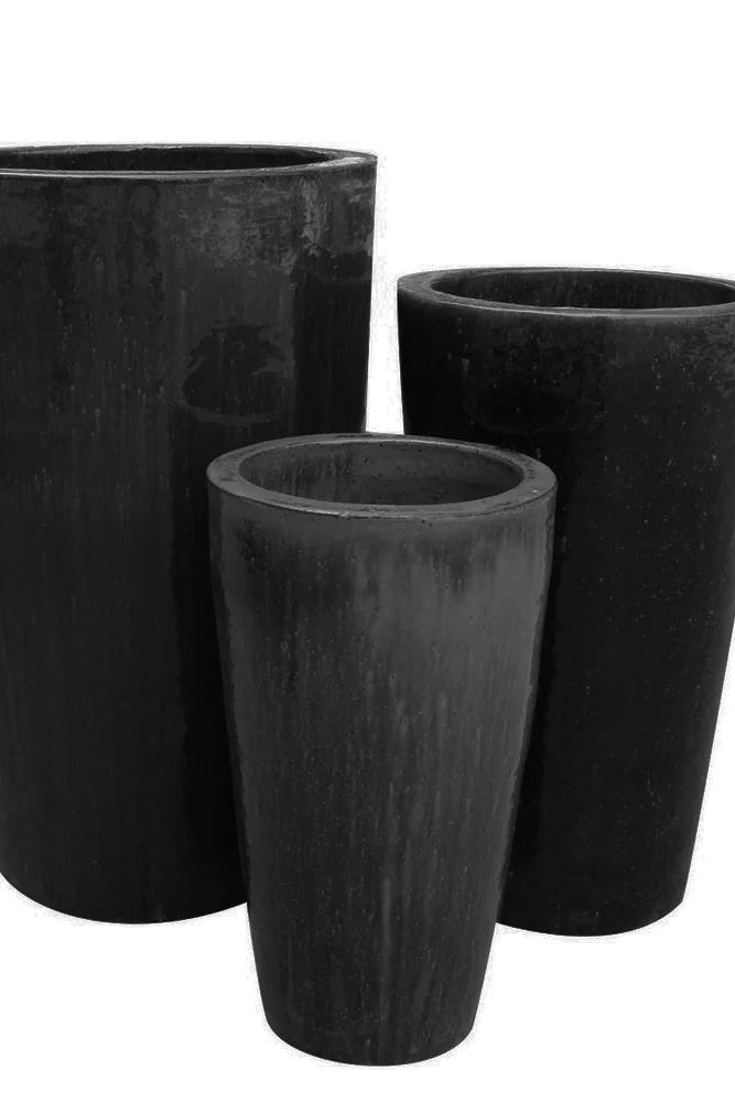 Three black cylindrical planters of different sizes on a white background ©Anamese