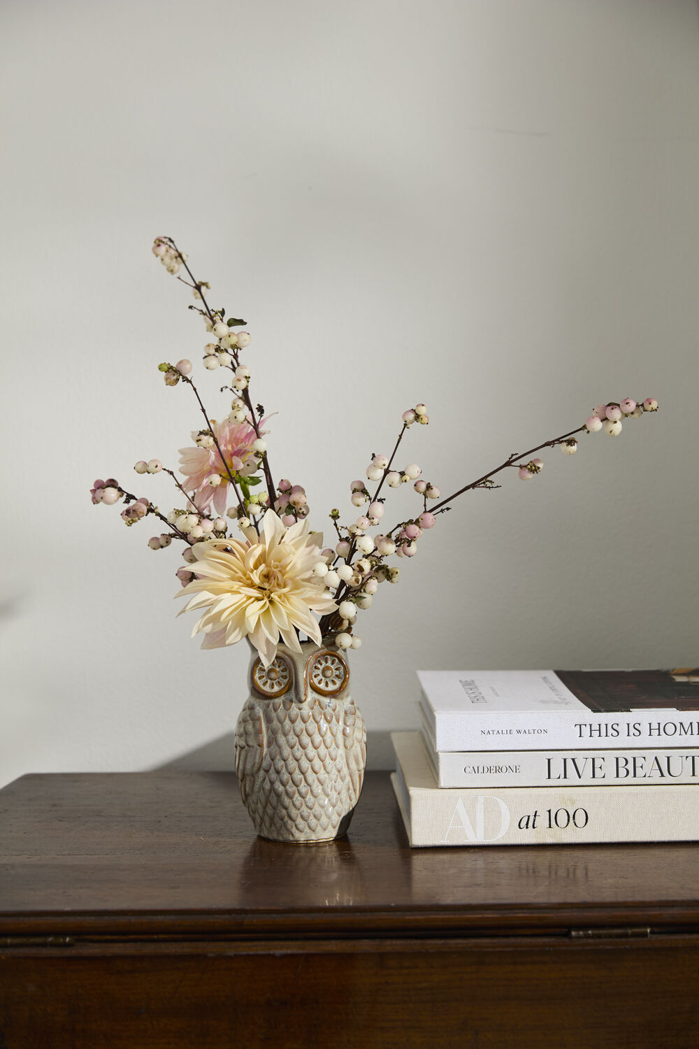 Decorative owl vase with flowers on a wooden surface against a plain wall ©Accent Decor
