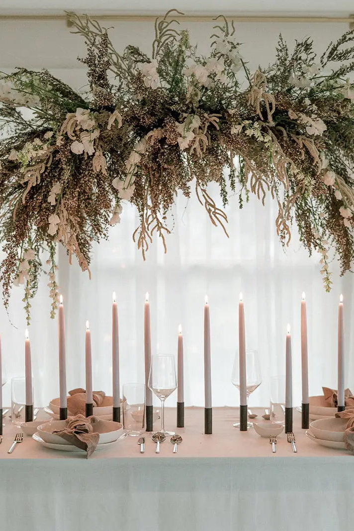 Decorative floral arch over a table with Bluebell 14" Beeswax Taper Candles by .candles and cutlery Mo & Co. ©Mo & Co