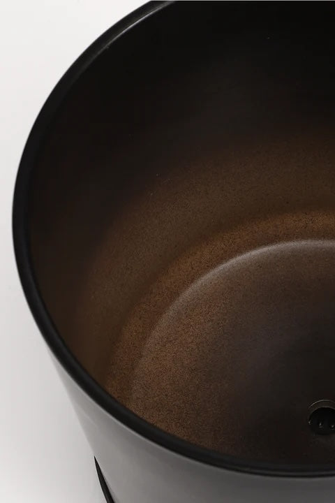 A black planter and saucer in front of a white wall. Looking in. ©LBE Design