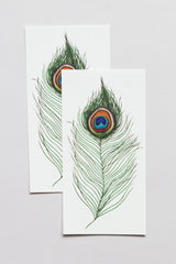 Peacock Feathers Tattoo's by Tattly on its white backing.