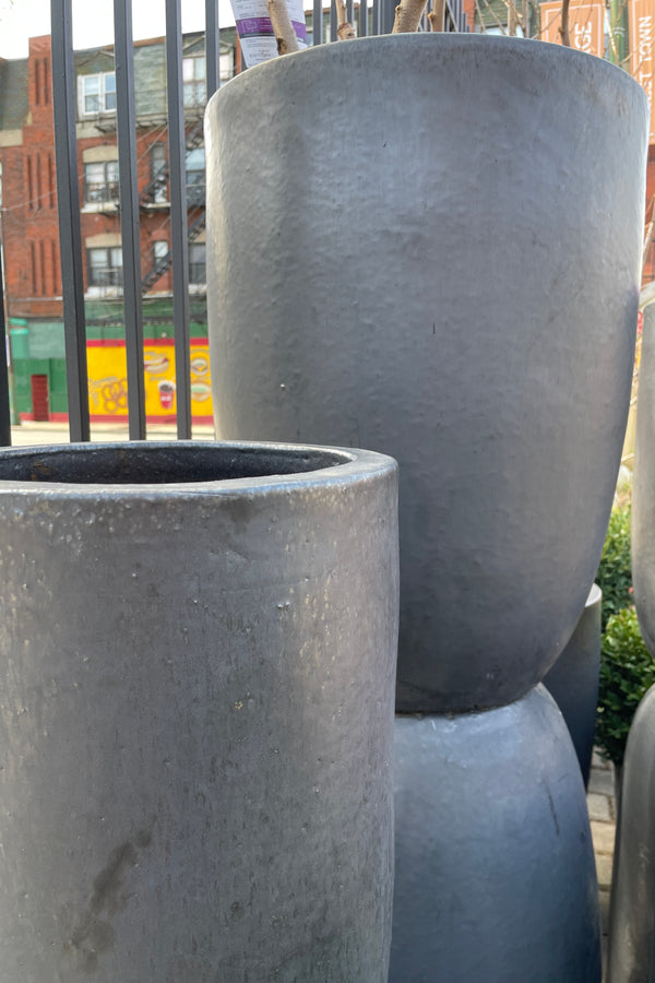 A group of Graphite crucible planters stacked without plant material in the Sprout Home yard. 