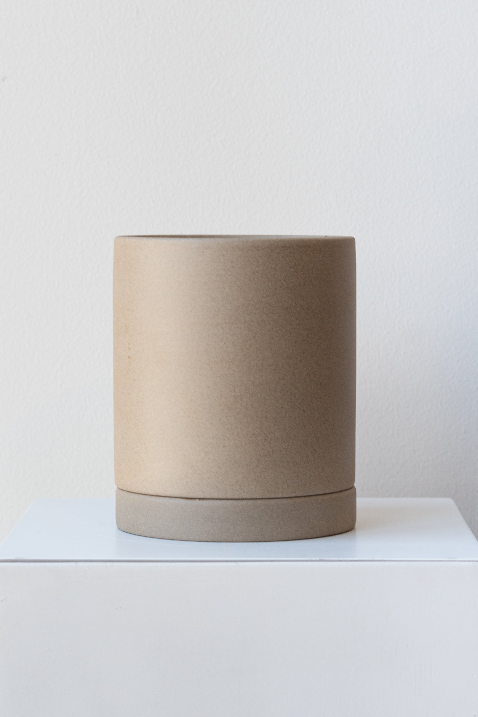 Sand medium Sekki plant pot by Ferm Living on a white pedestal in front of a white background