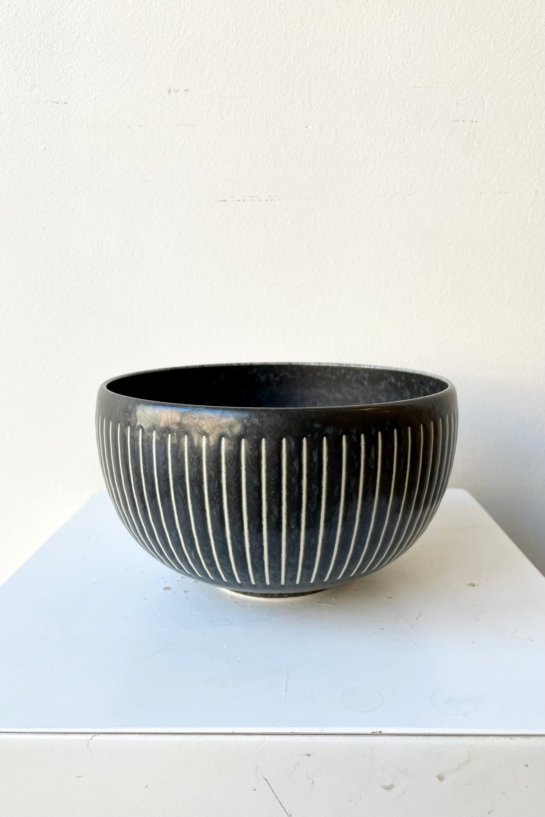 The Black Horsetails Bowl extra large against a white wall at Sprout Home. ©Sprout Home
