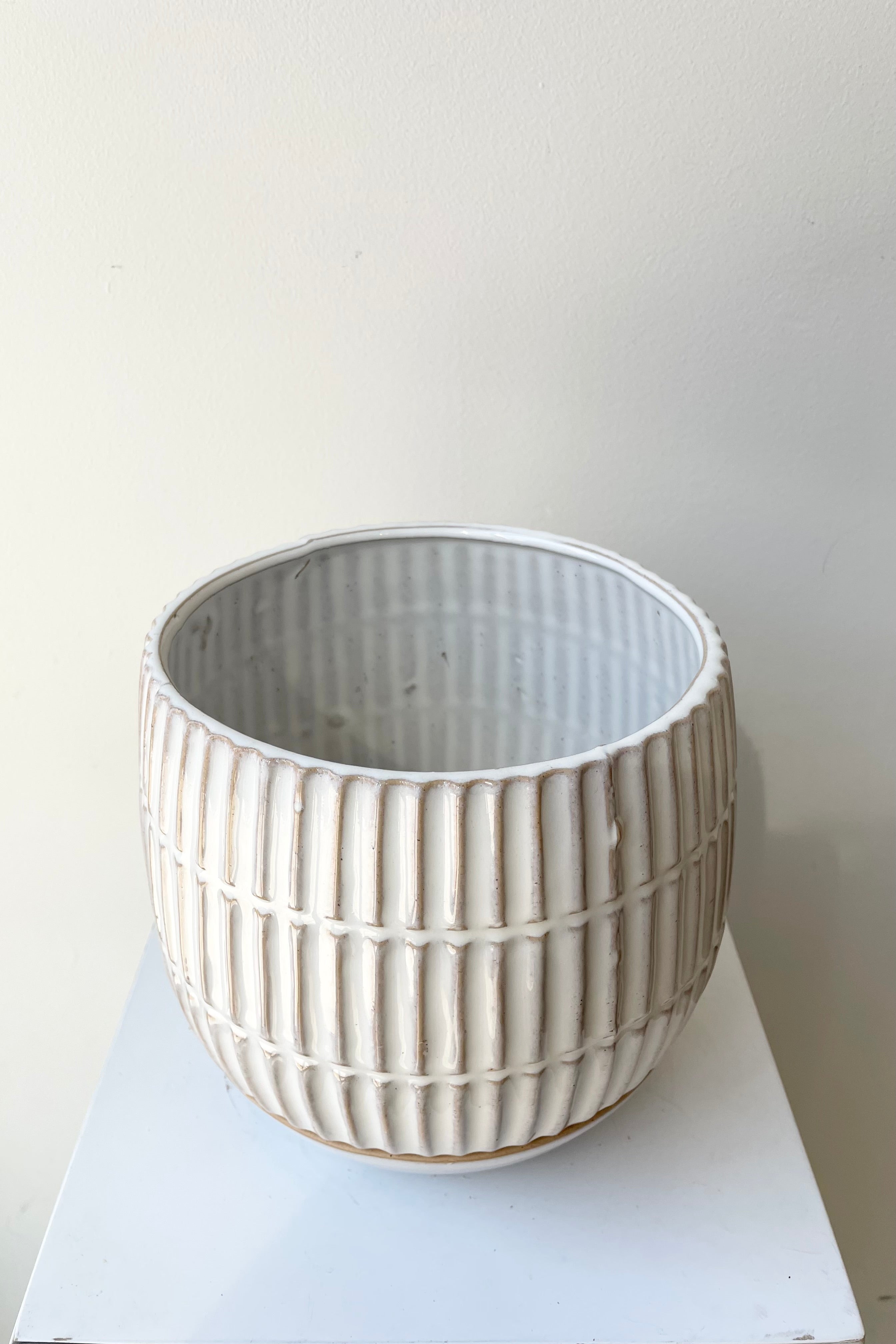 The 6" Ramos planter with saucer against a white wall at Sprout Home.