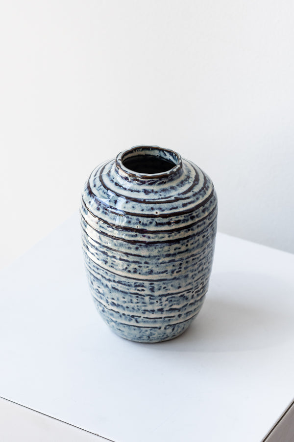 Striped blue and white glazed small Toku vase by Homart on a white surface in a white room