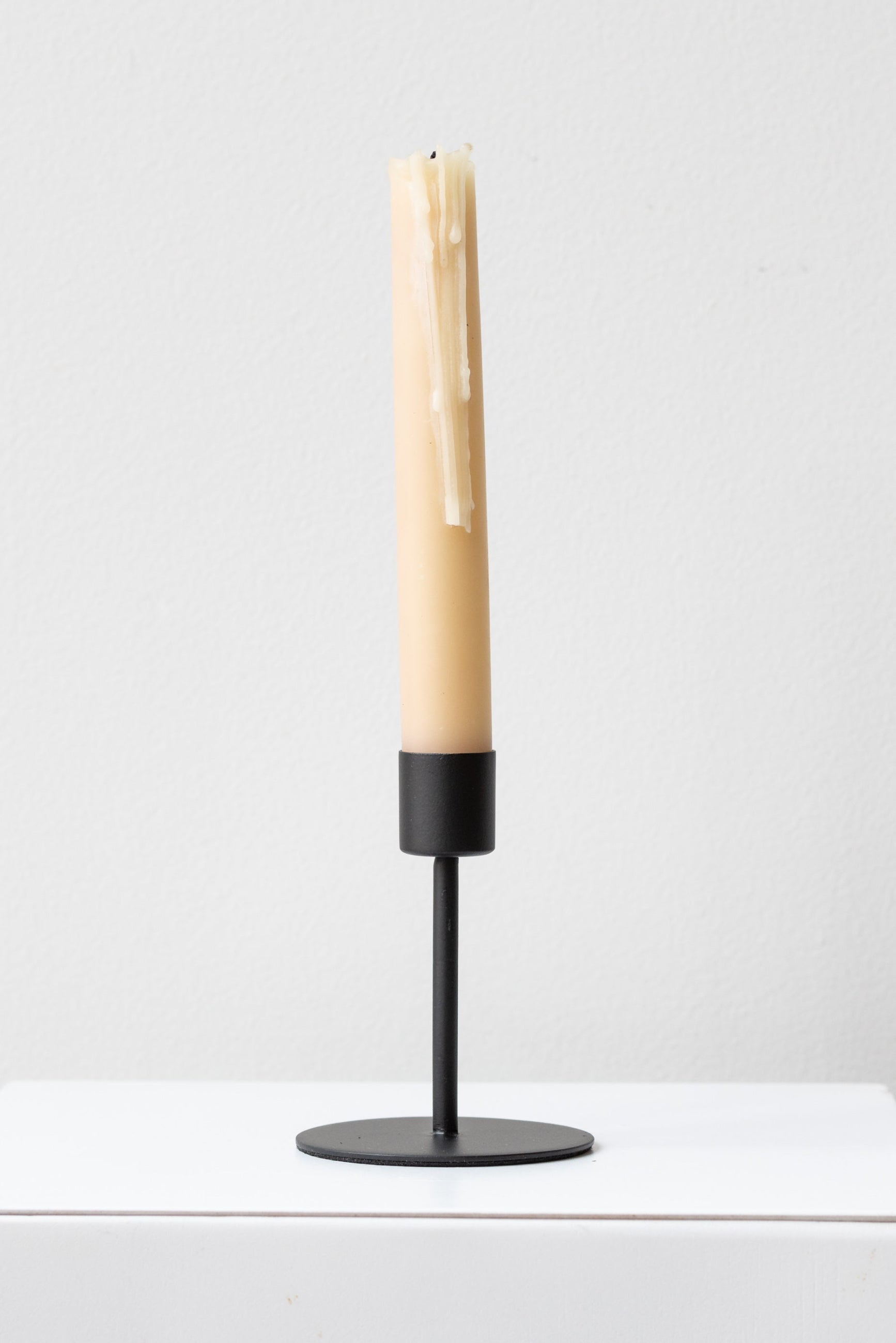 Black Kent MEDIUM candlestick holder with a neutral off white slightly burnt taper candle inside ©Sprout Home