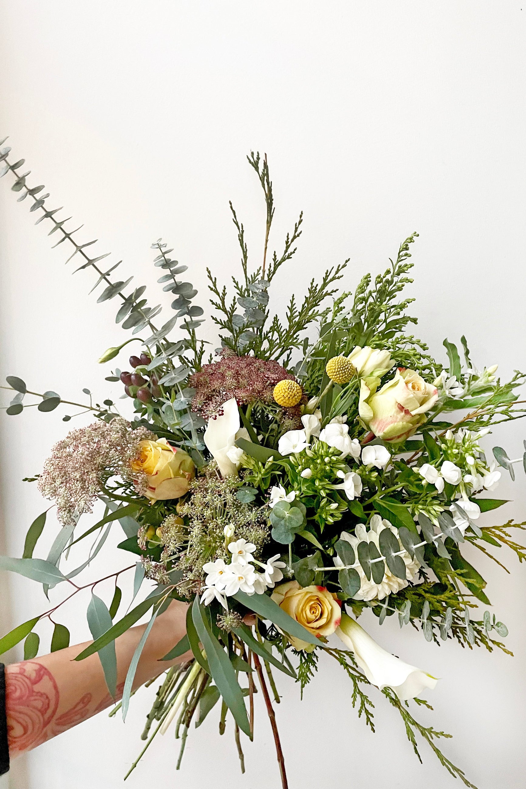 A hand holds an example of fresh Floral Arrangement Eggnog from Sprout Home Floral in Chicago ©Sprout Home #size_$130