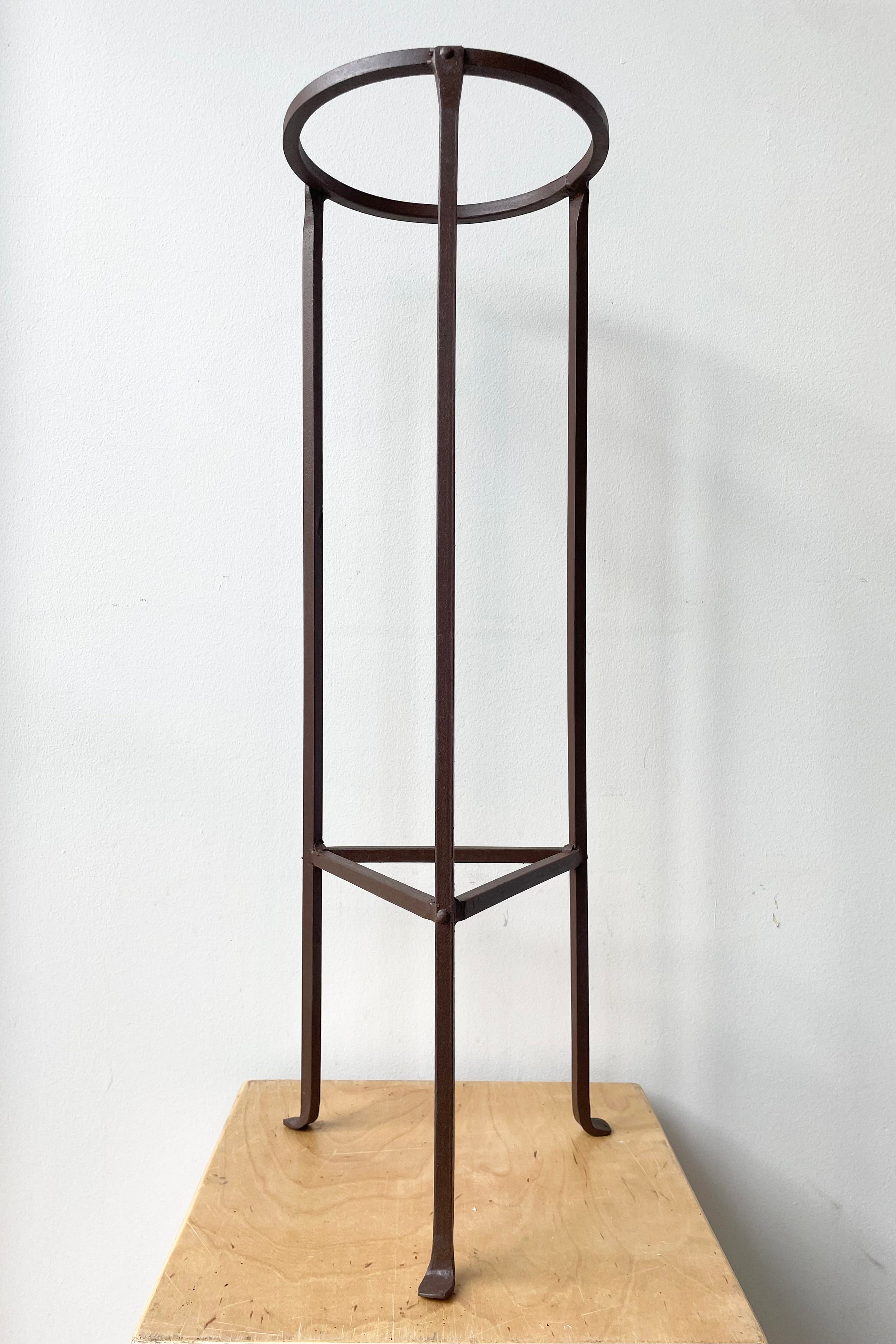 Iron Plant Stand Medium 8"dia x 26.5"H against a white wall