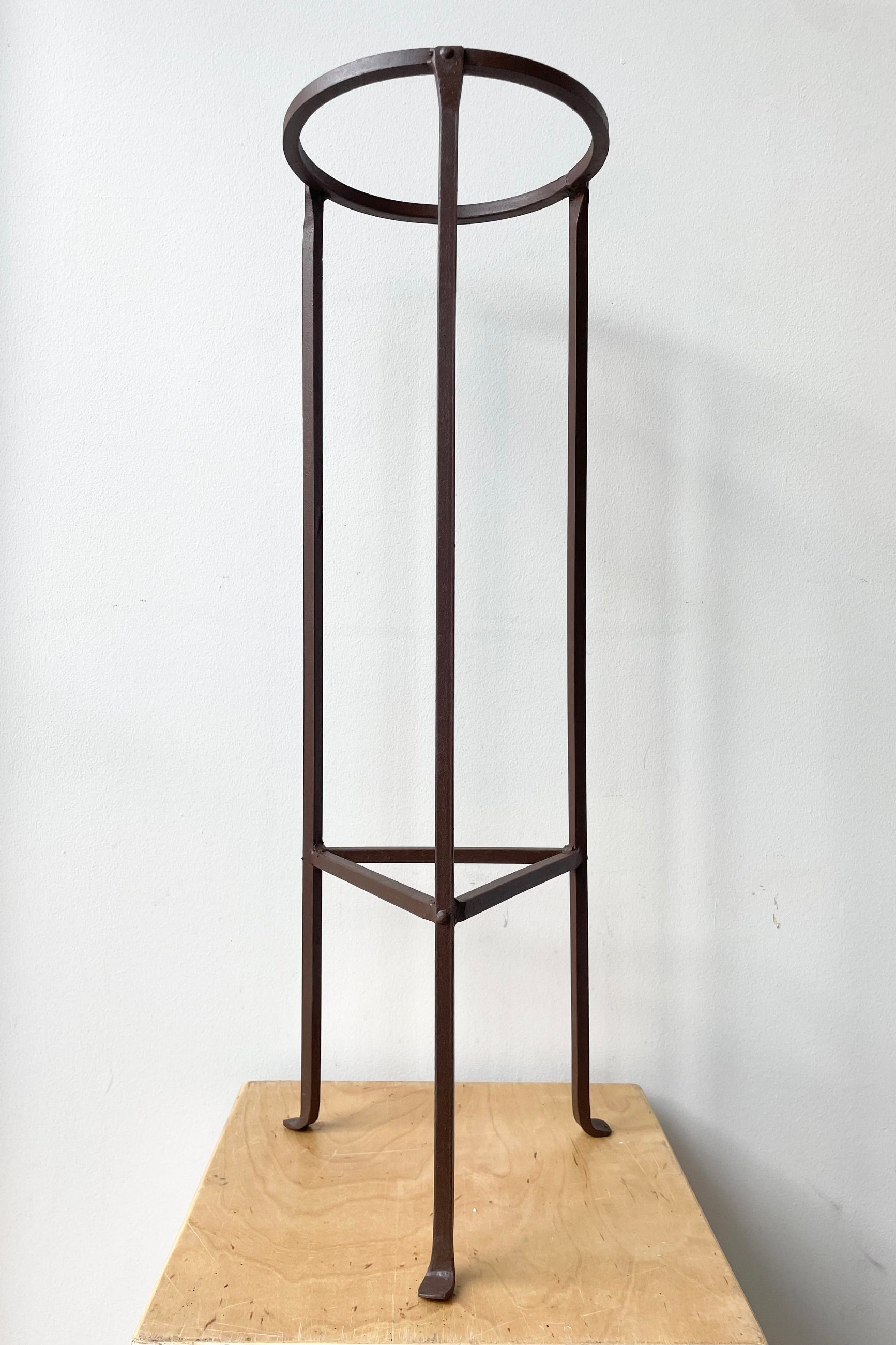 Iron Plant Stand Medium 8"dia x 26.5"H against a white wall ©Sprout Home